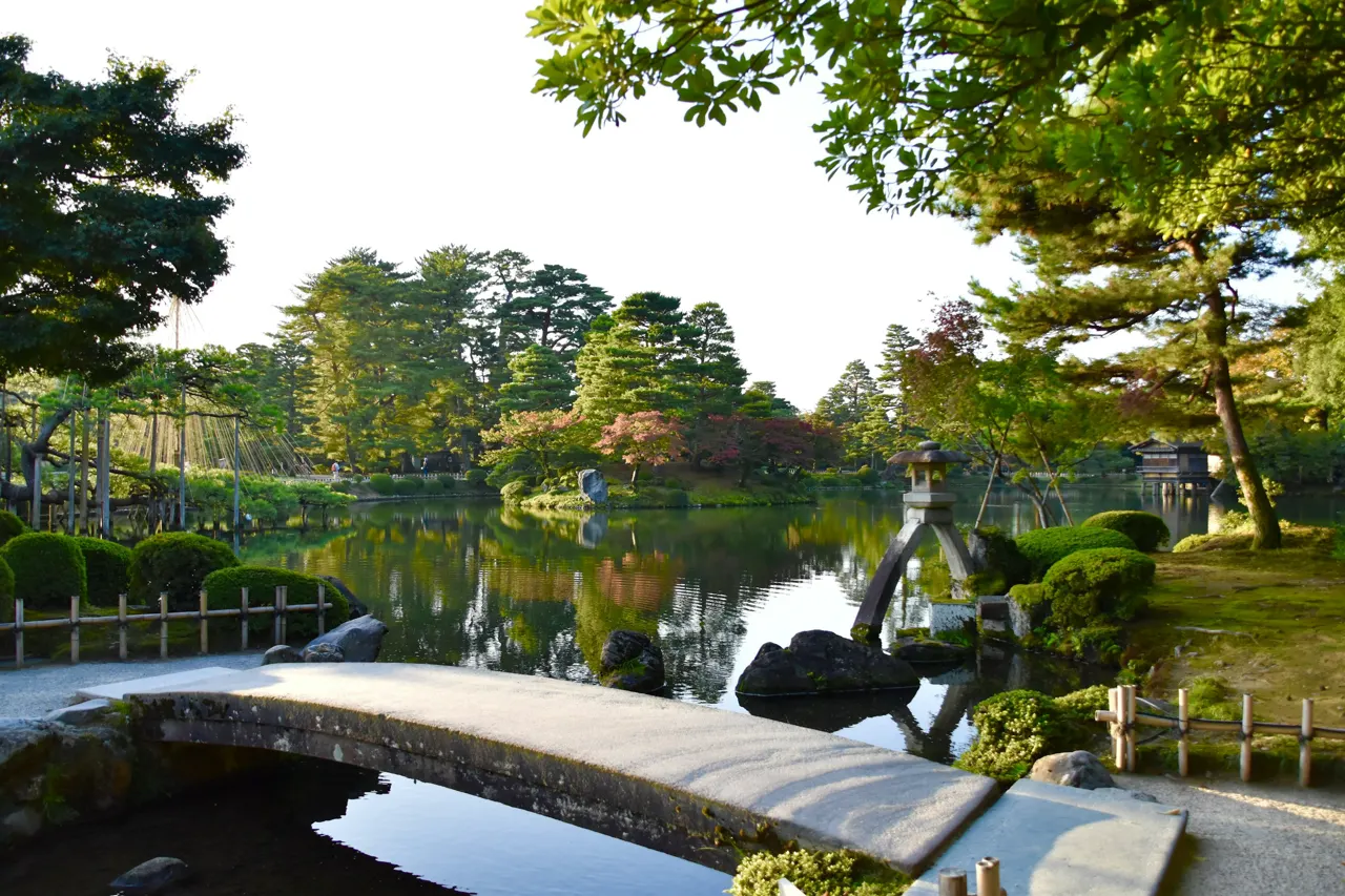 A bridge over a pond in a park