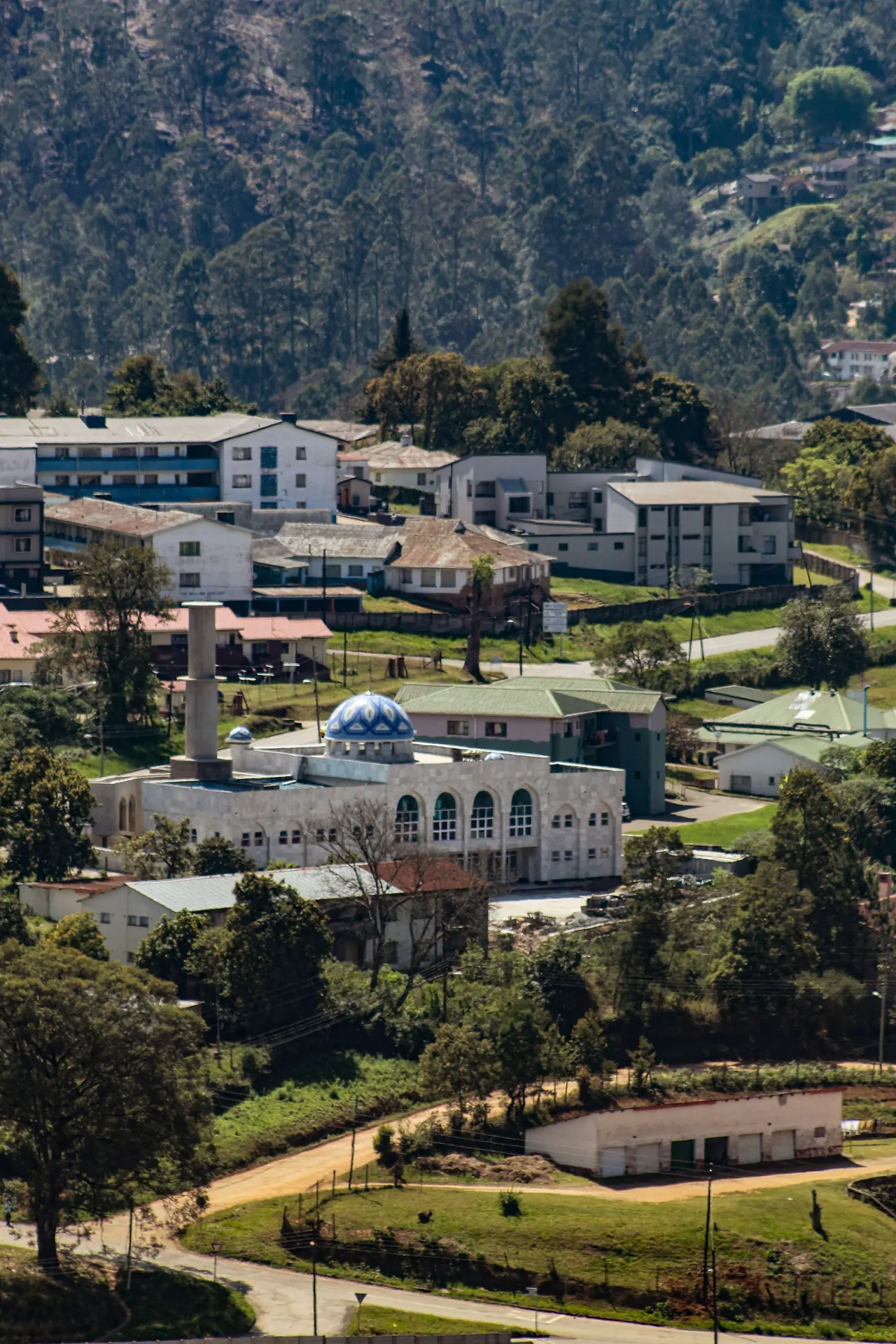 A mosque and buildings nestled amongst hills