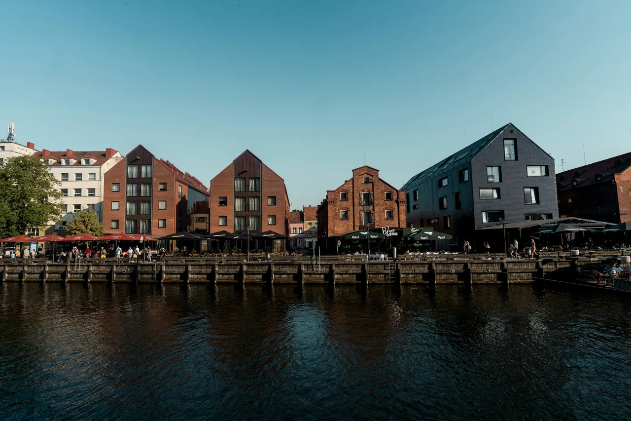 Buildings line the waterfront under a clear, blue sky