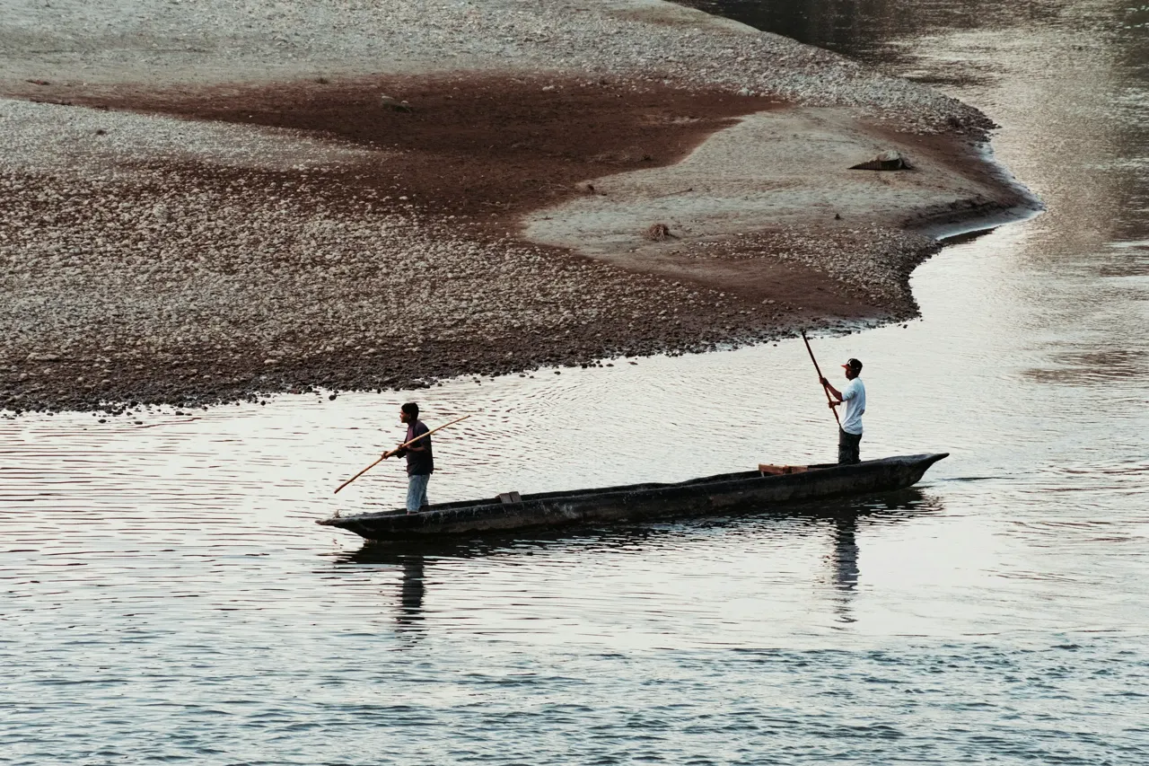 Two people in a small boat on a river