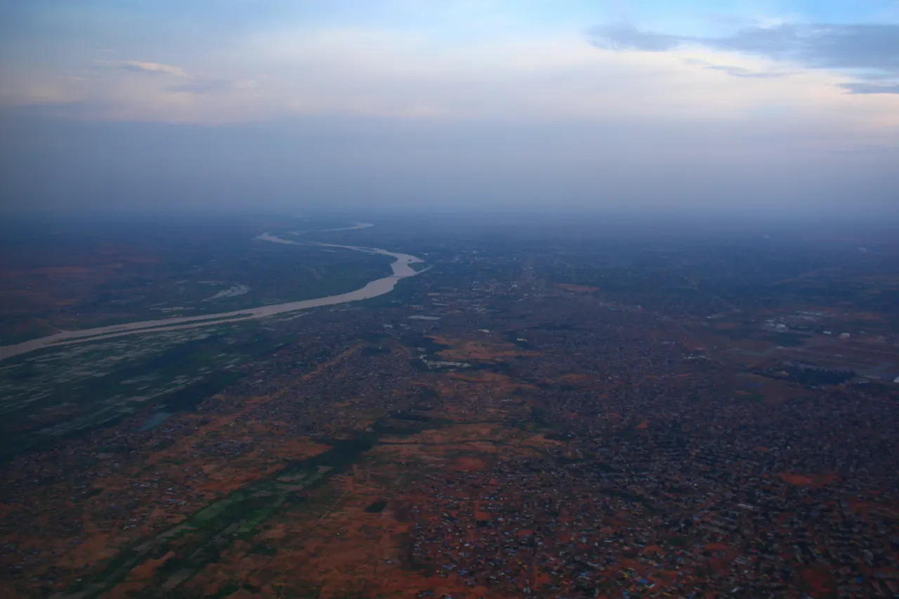 Winding river flows through a wide, arid landscape