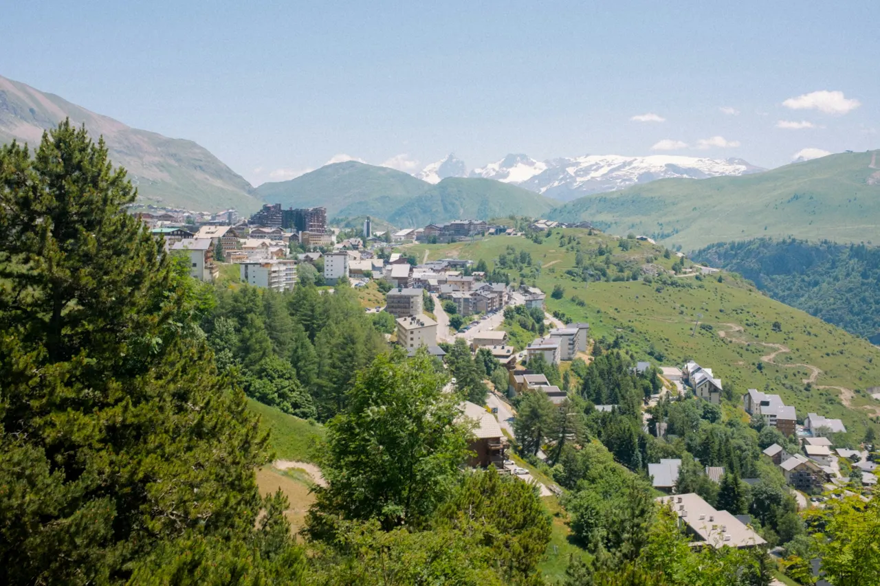 A mountain village with snow-capped peaks in the distance