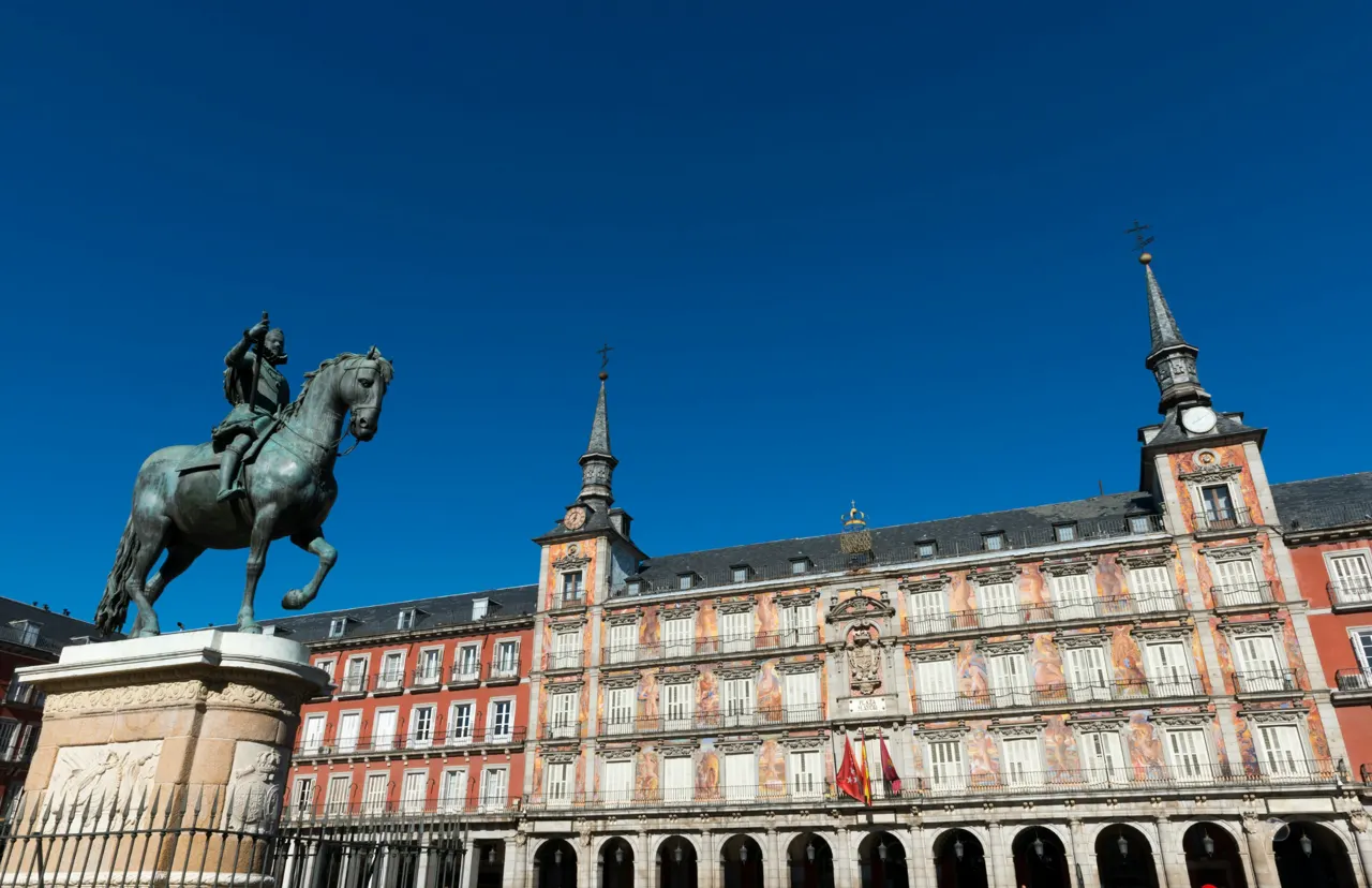 An equestrian statue at Plaza Mayor in Madrid under a blue sky