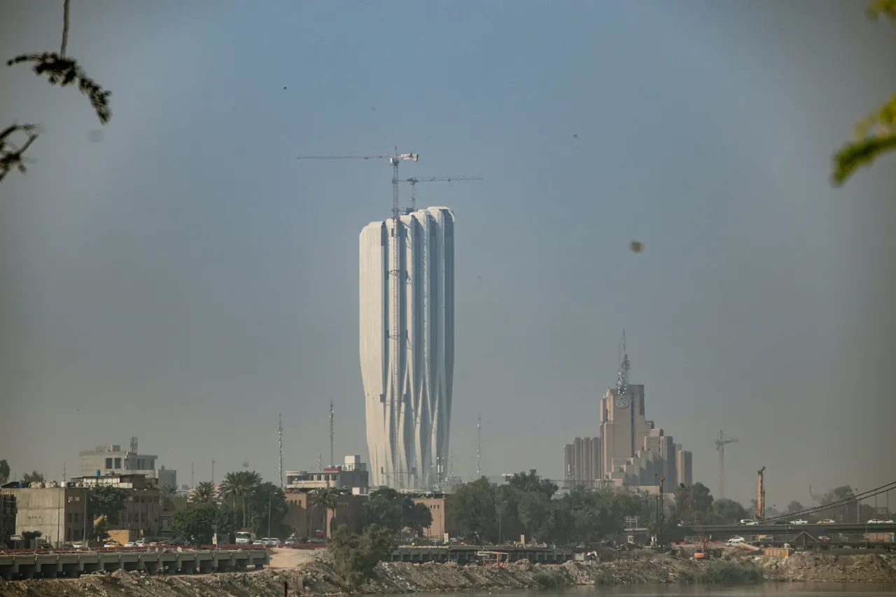 A tall white building sitting next to a body of water