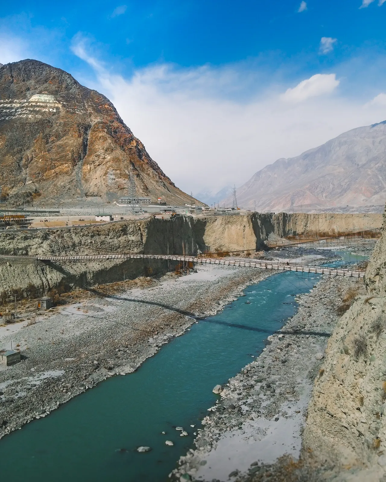 a river running through a valley surrounded by mountains
