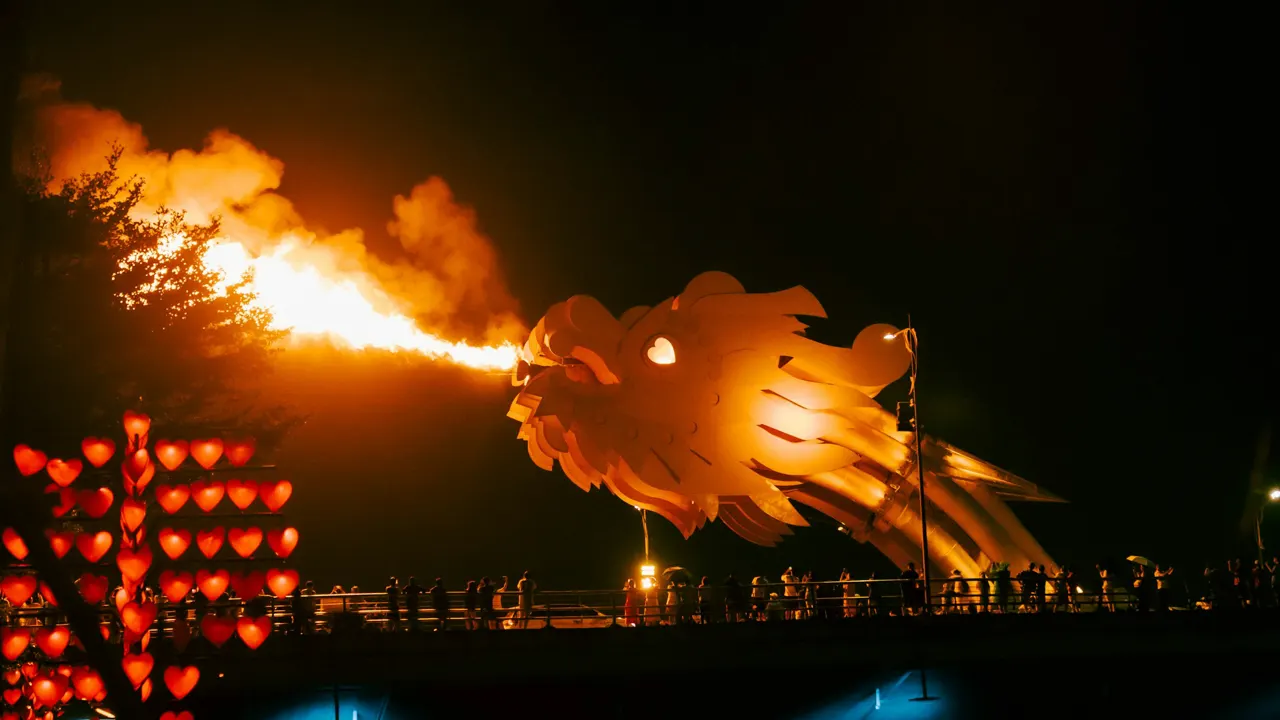 a large fire breathing sculpture is lit up at night