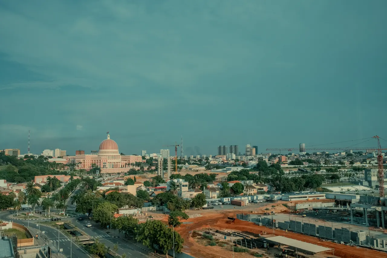 A cityscape is under a cloudy blue sky