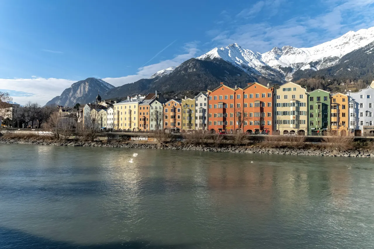 a river running through a city with mountains in the background