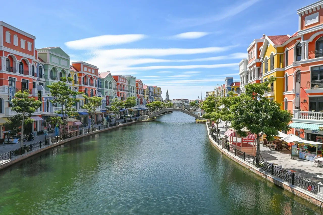 Colorful buildings line a canal with a bridge