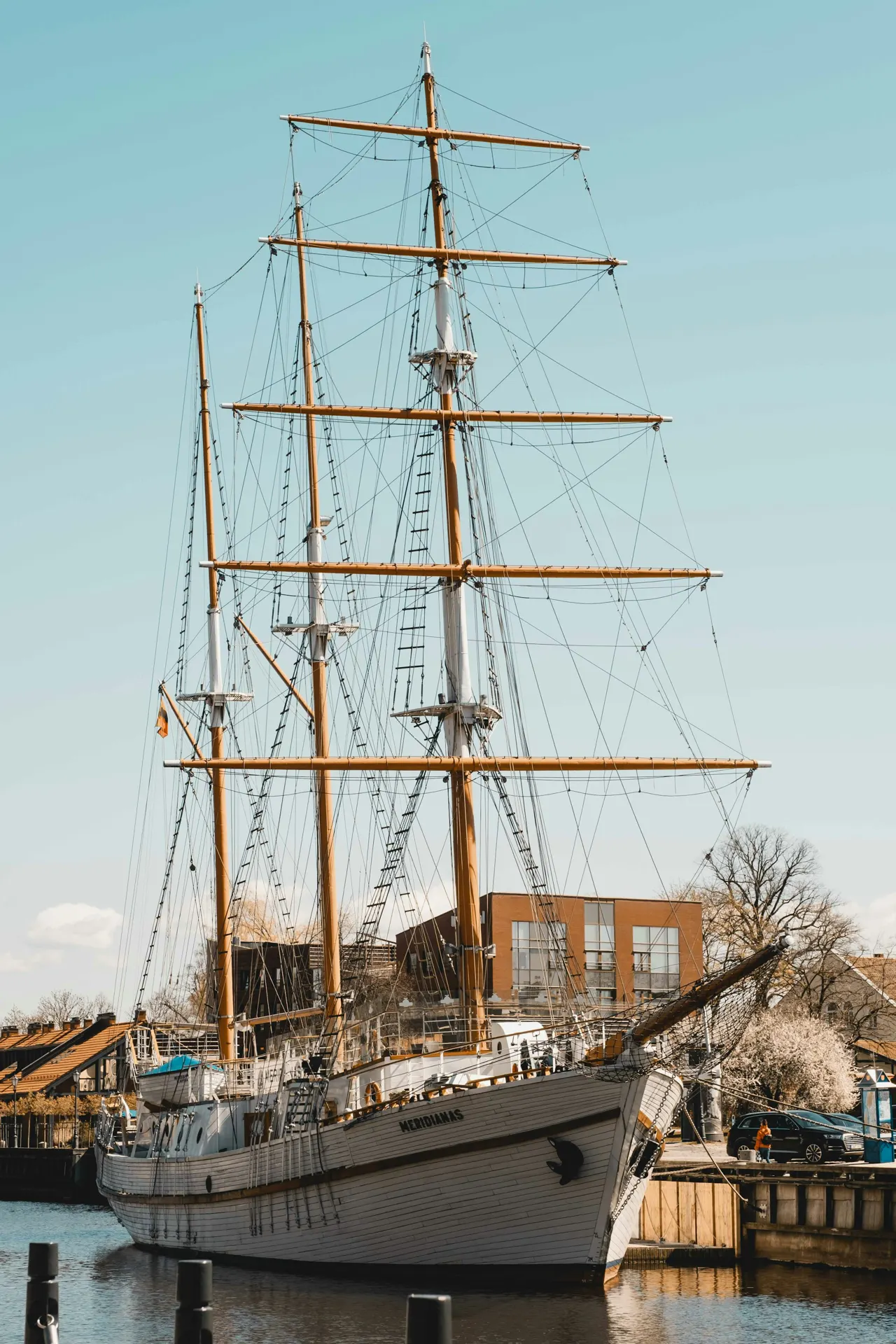 a large sailboat docked with HMS Warrior 1860 in the background