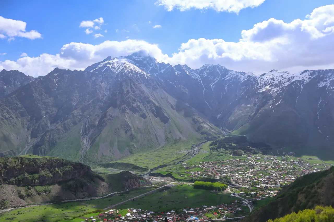 a valley surrounded by mountains with a small village in the middle