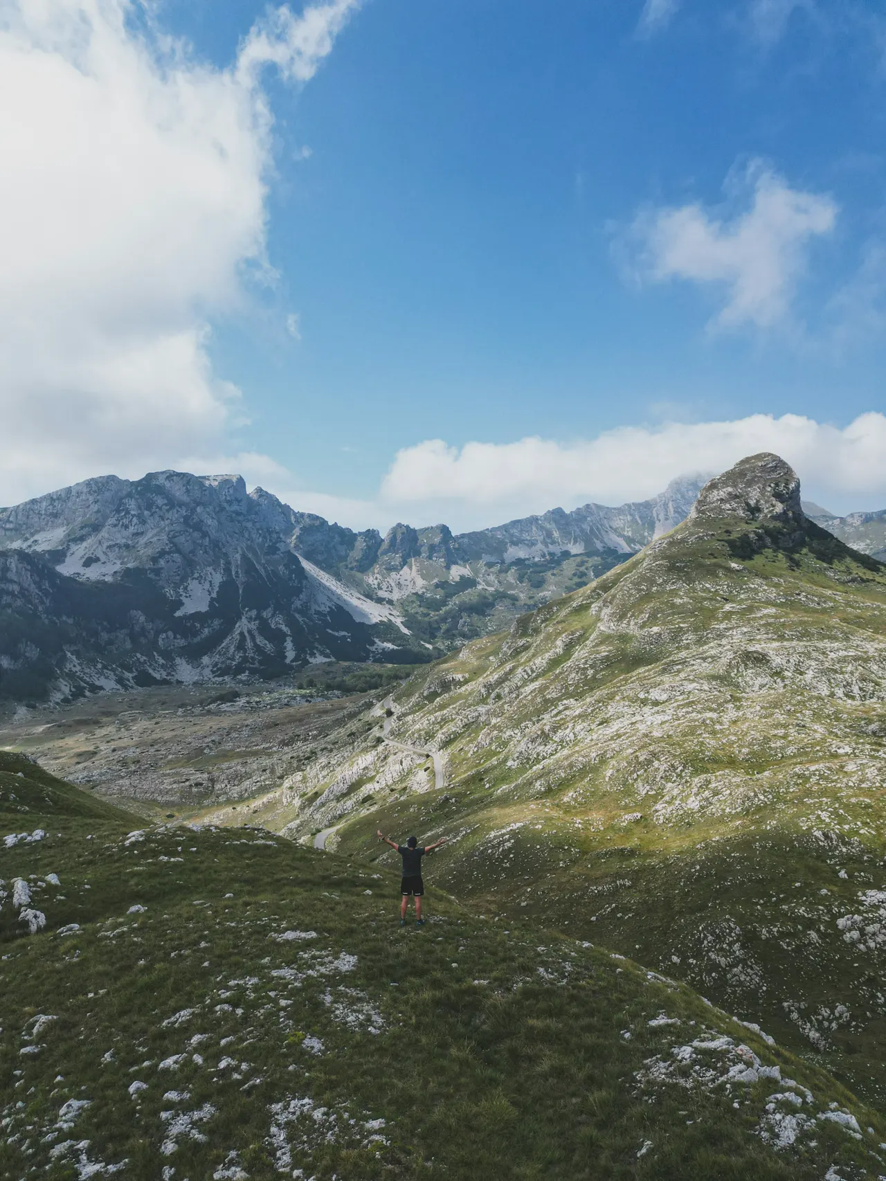 a man standing on top of a lush green hillside
