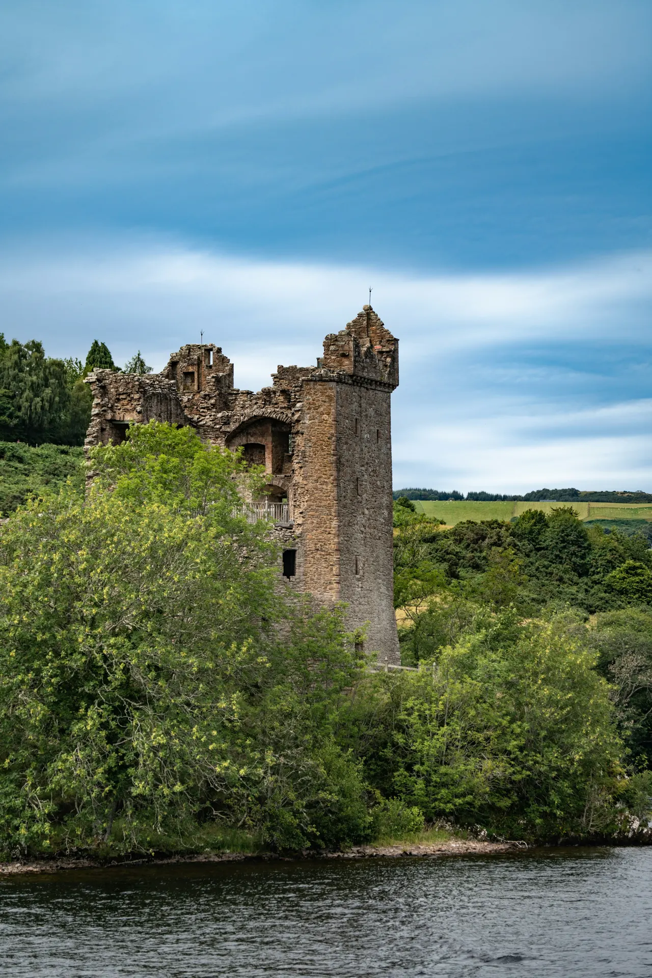 a castle sitting on top of a lush green hillside