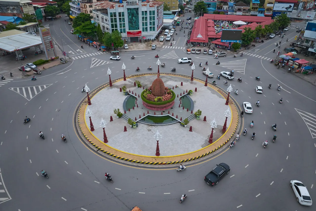 An aerial view of the Durian Roundabout with traffic in Kampot, Cambodia