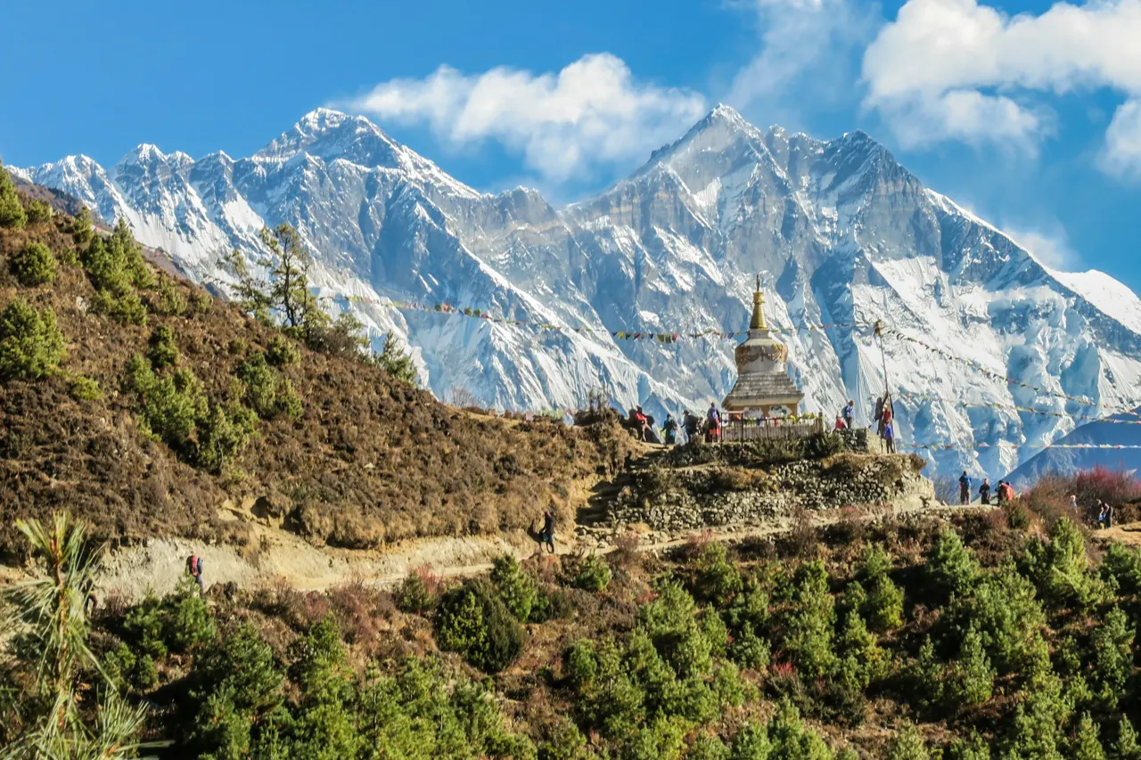 A Buddhist stupa with prayer flags before snow-capped Himalayan peaks in Nepal