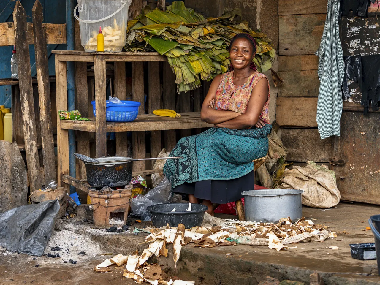 Smiling woman sits near her food stand