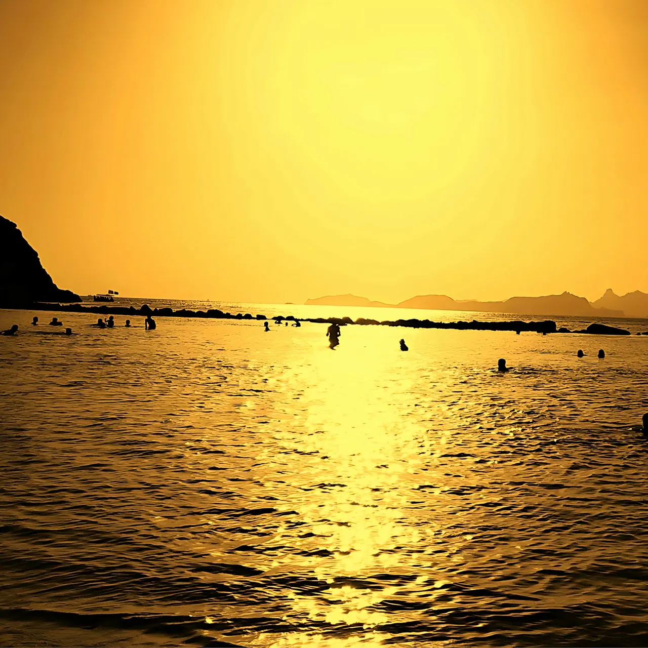 The image shows a sunset over a mountainous landscape