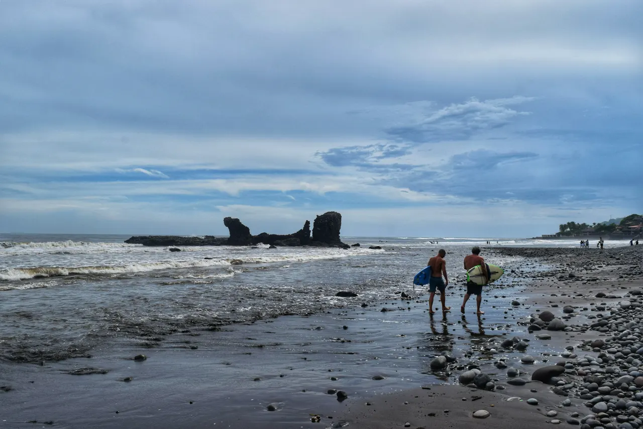 Surfers walking on "El Tunco" beach, La Libertad, El Salvador, July 2024