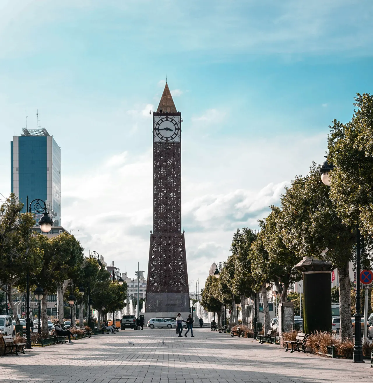 a tall clock tower sitting on the side of a road