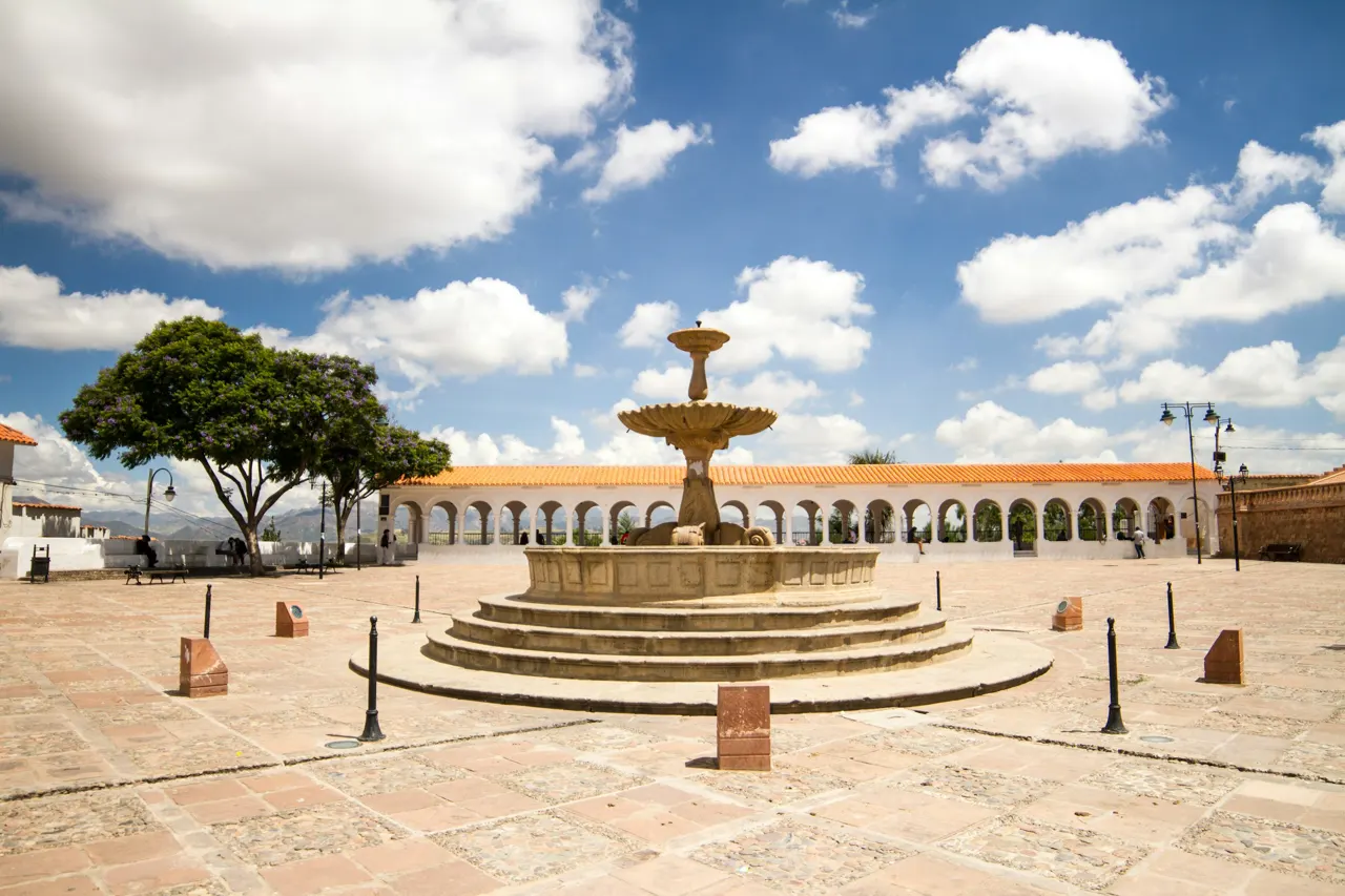 A stone fountain in a sunny town square