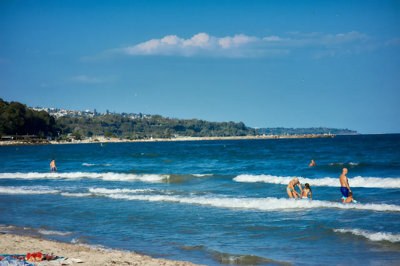 A group of people playing in the water at the beach