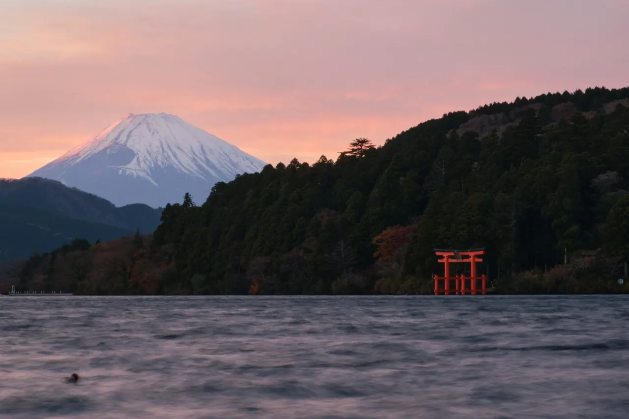 A body of water with a mountain in the background