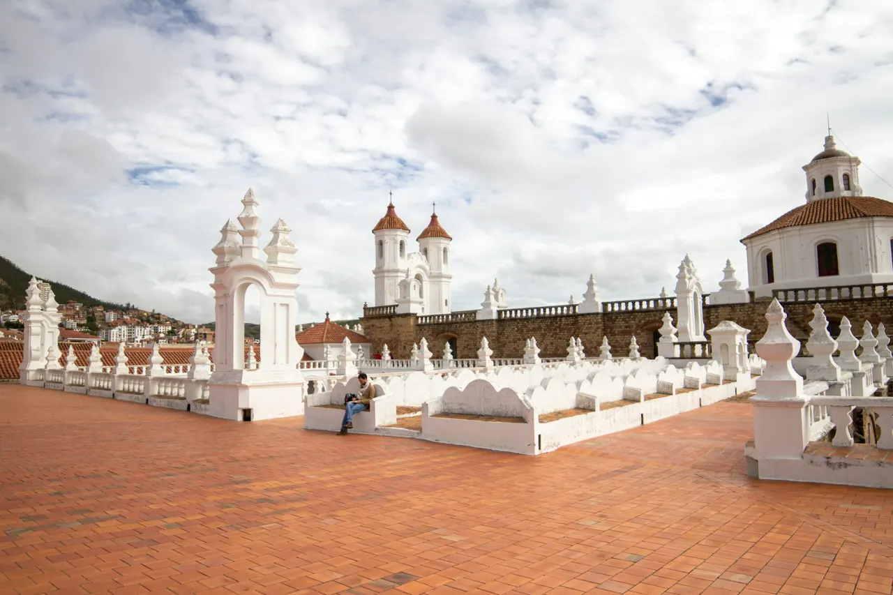 White colonial buildings with towers under cloudy sky