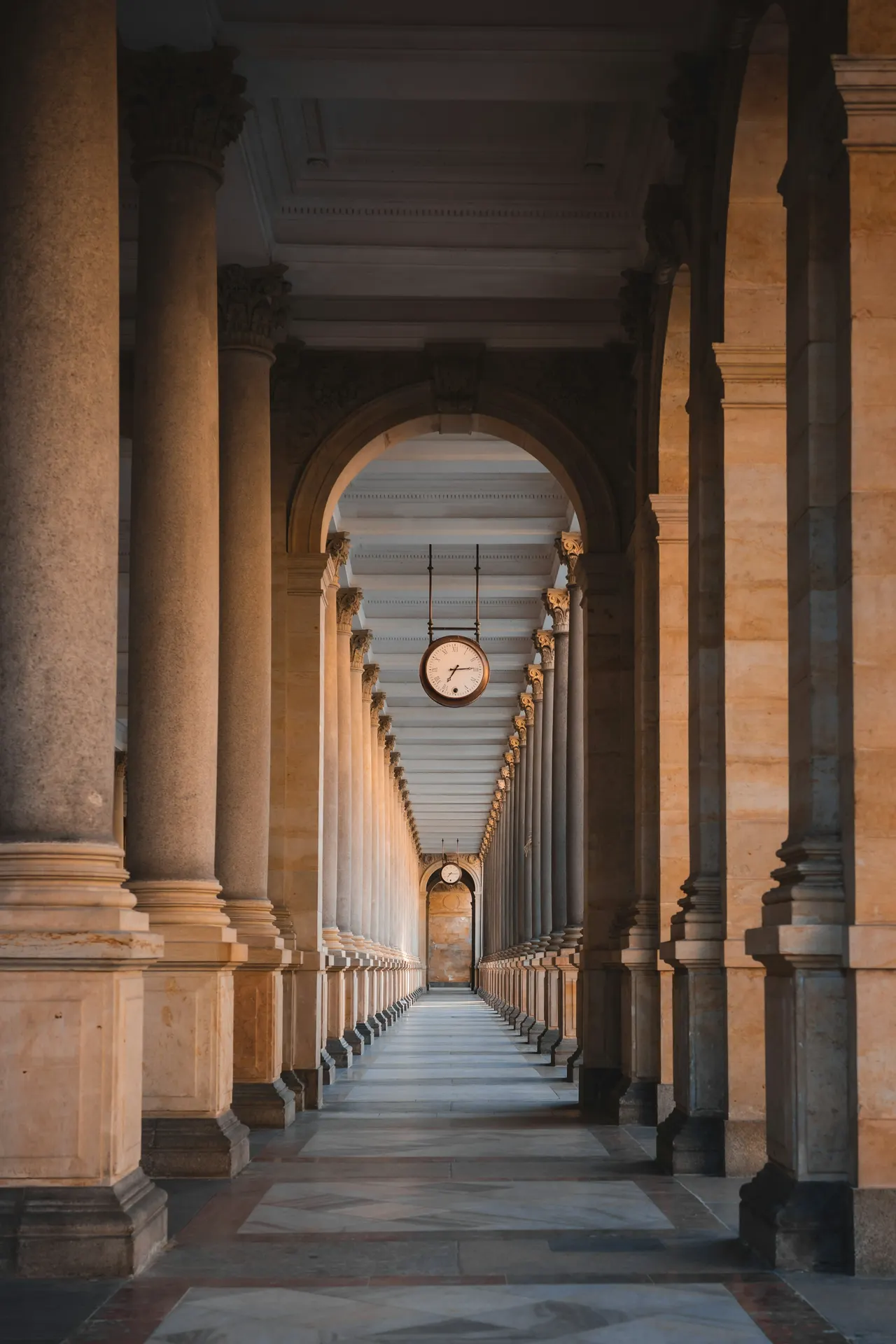 a clock hanging from the ceiling of a building