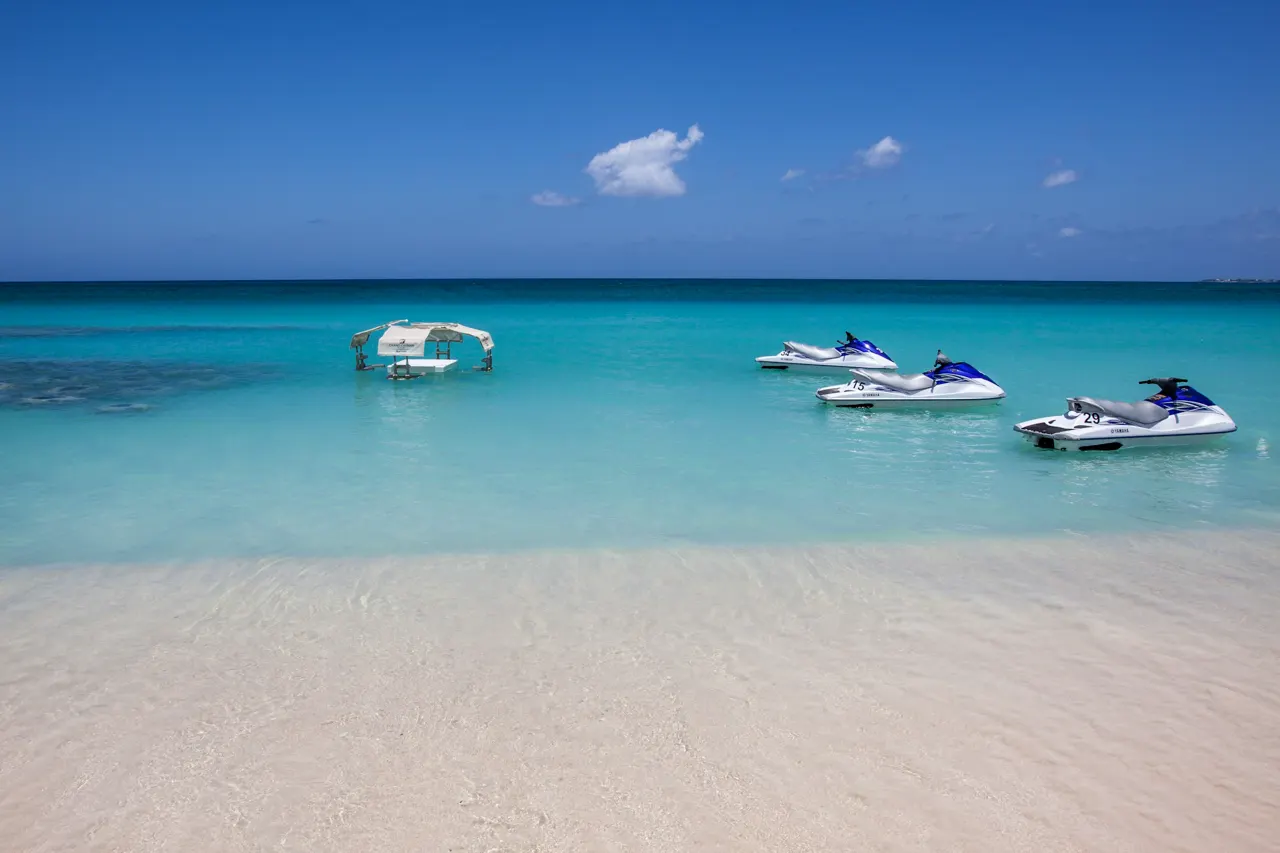 Jet skis float in crystal-clear turquoise water