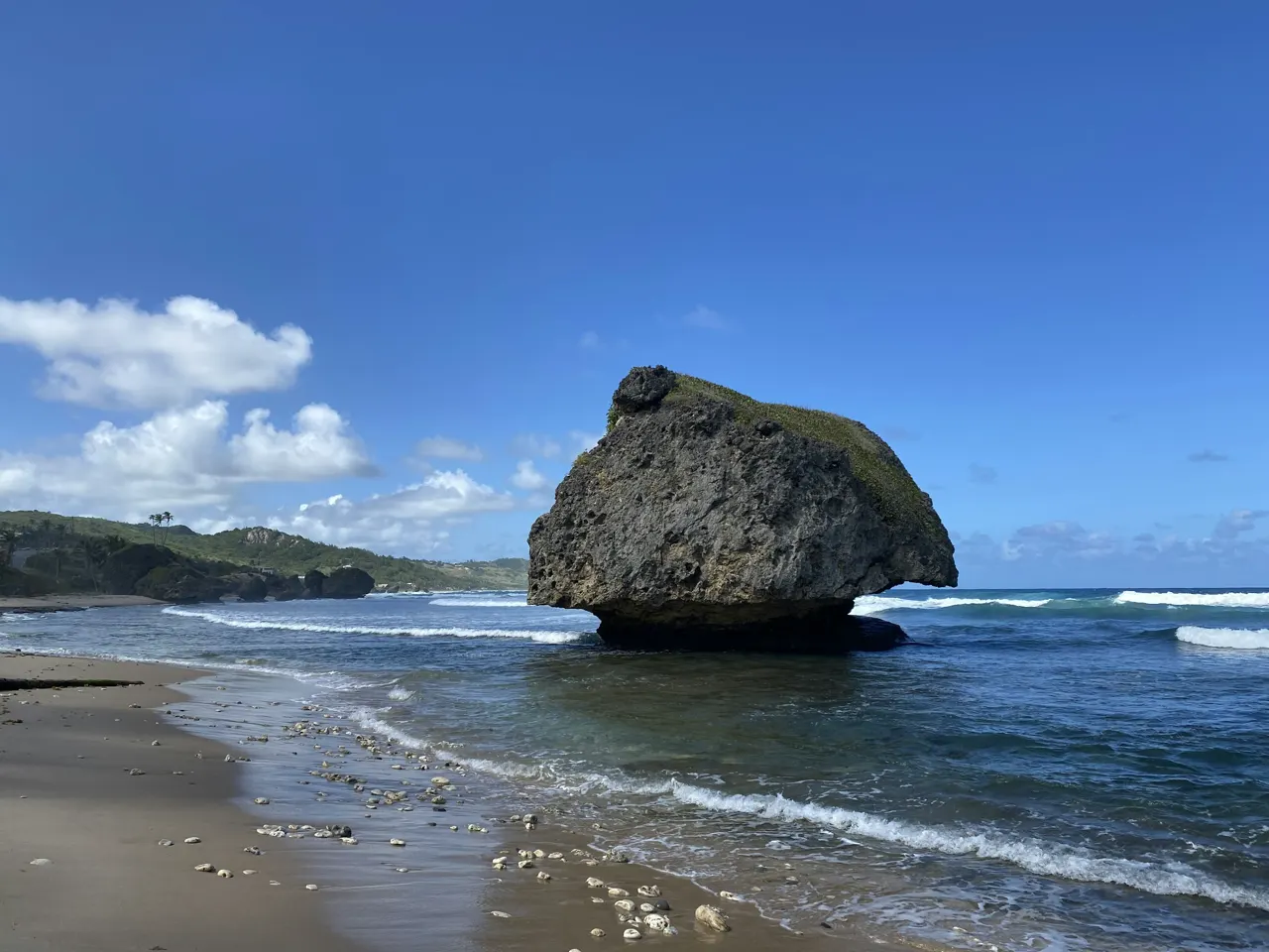 a large rock sitting on top of a sandy beach