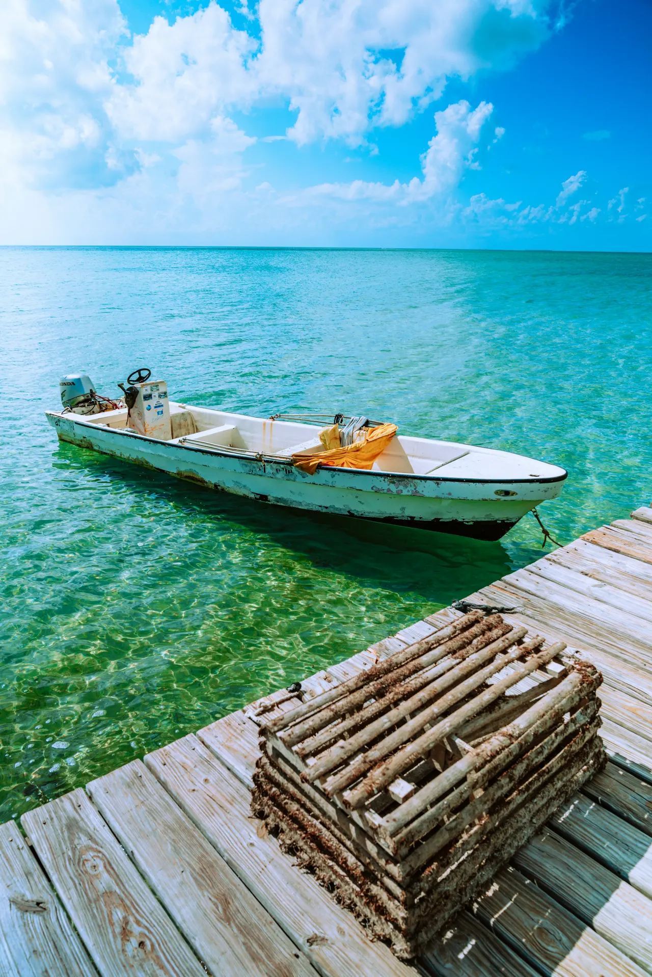 Small motor boat at a dock with a wooden crab trap