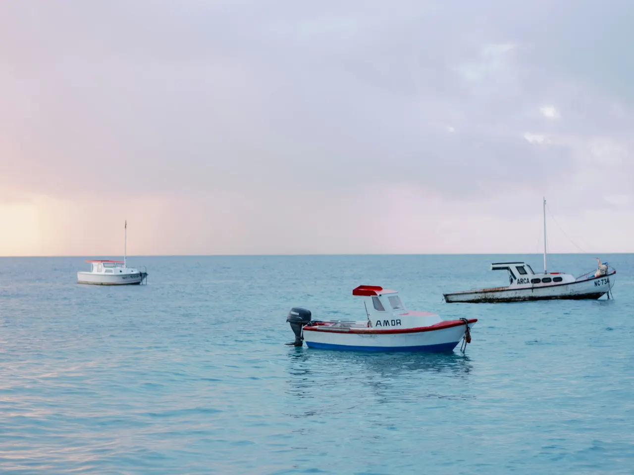 a group of boats floating on top of a large body of water