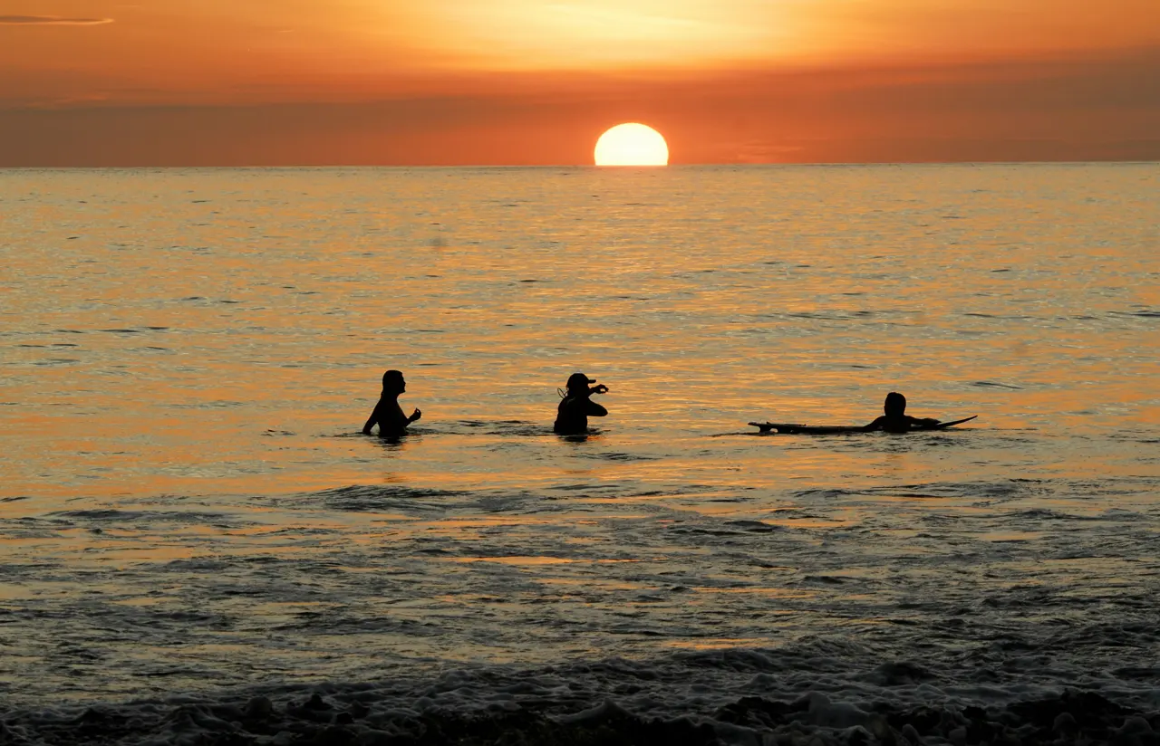 silhouette of people on sea during sunset
