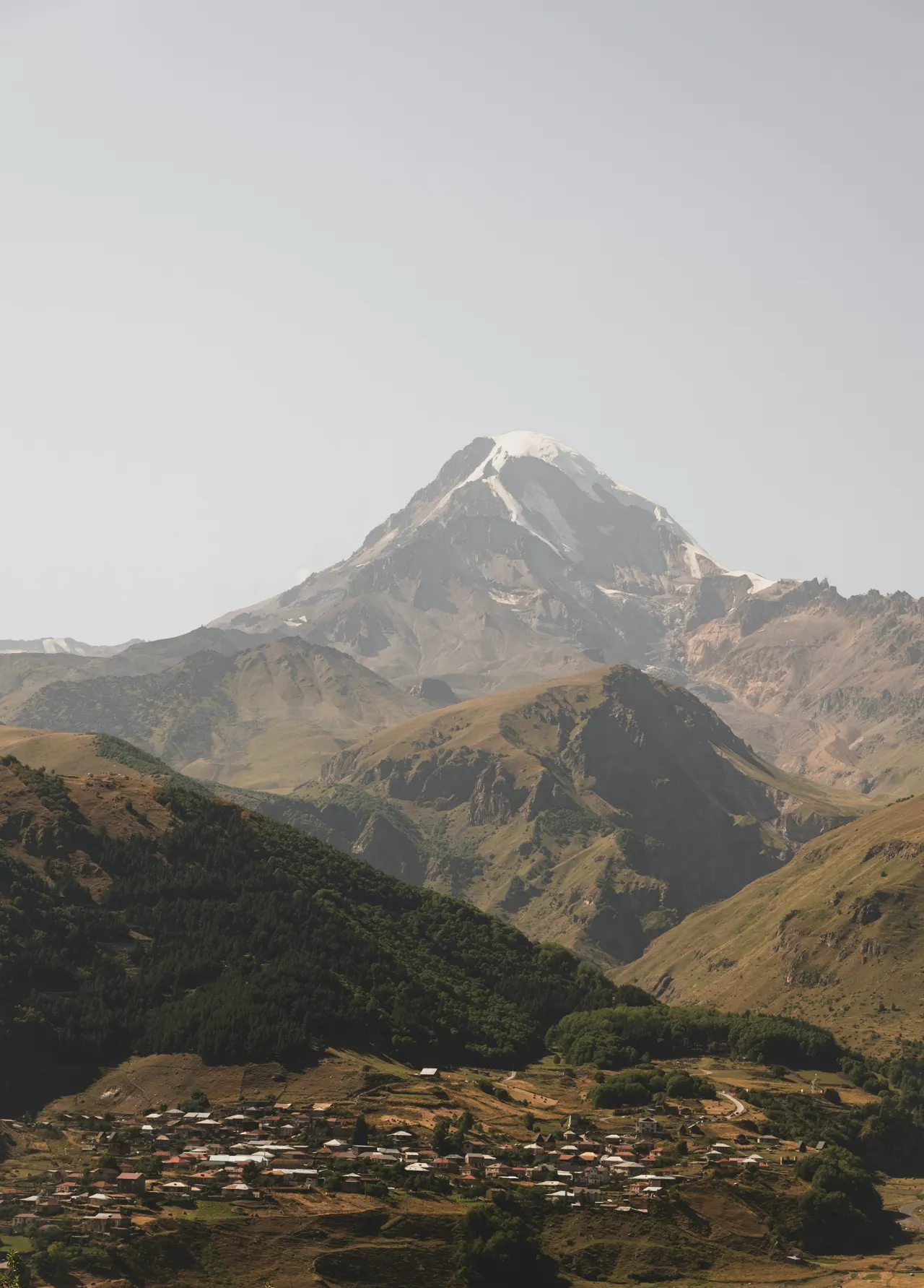 Snow-capped mountain peak above a village
