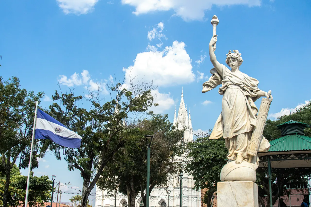 a statue of a woman holding a cup in front of a building