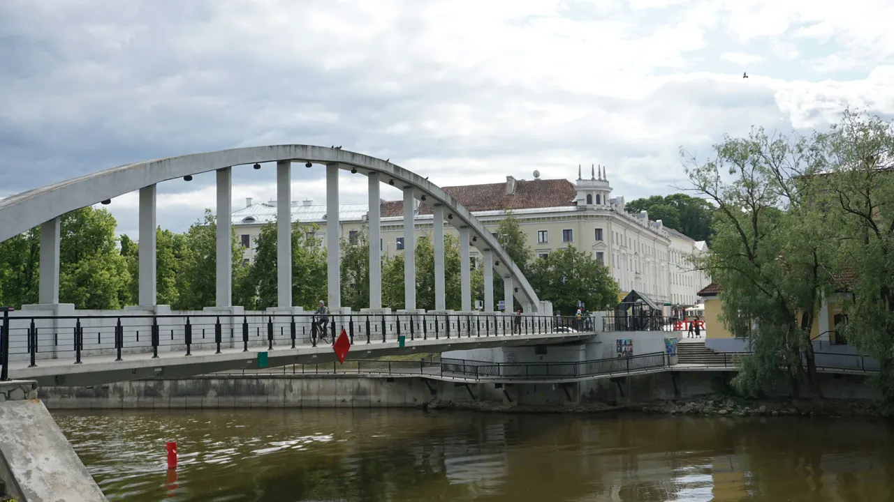 a bridge over a body of water with a building in the background