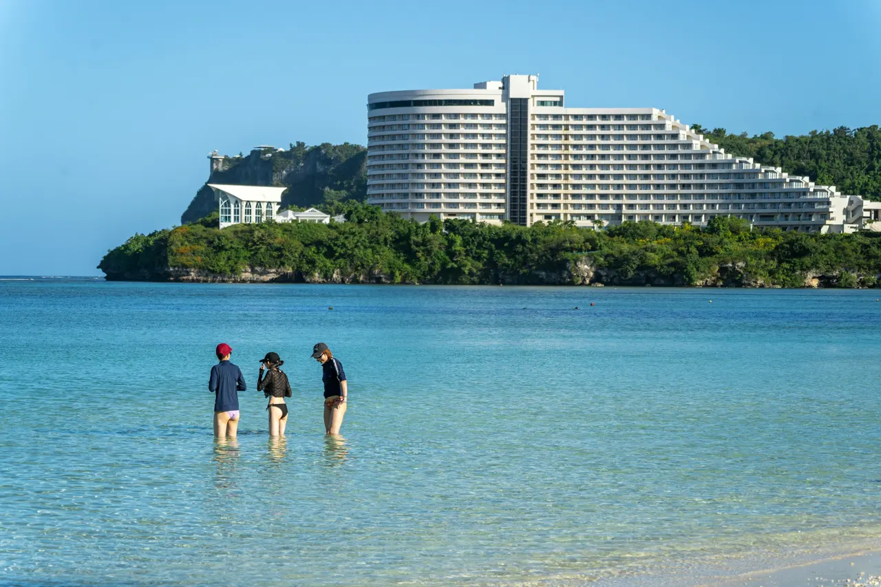 A group of people standing on top of a sandy beach