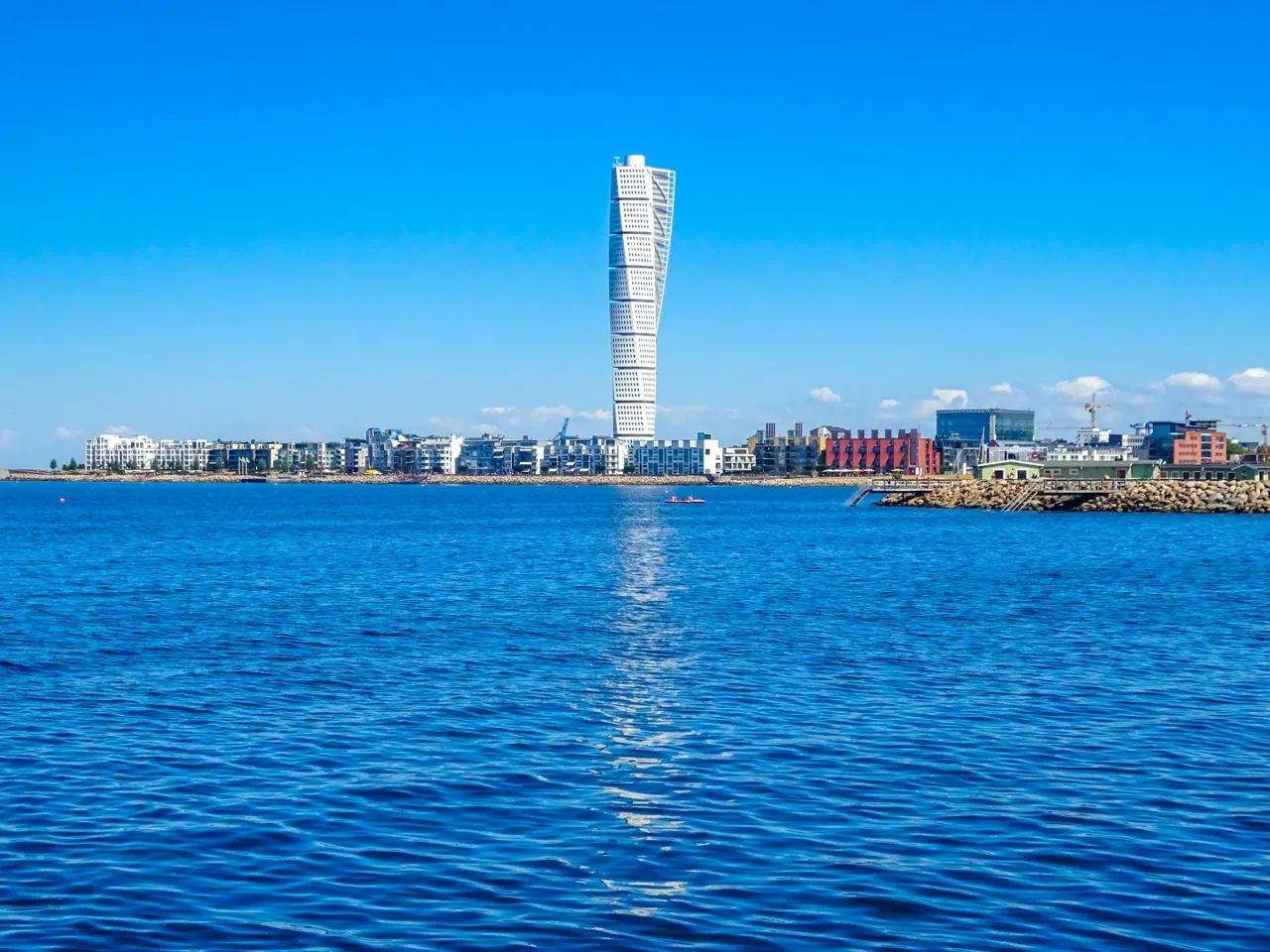 Modern skyscraper reflected in calm blue water
