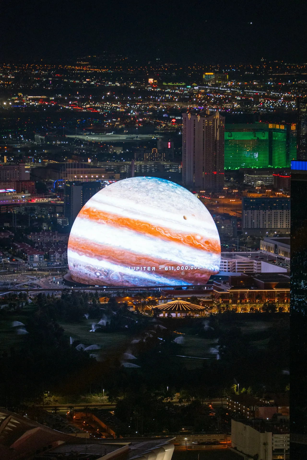 Jupiter projects over a cityscape at night