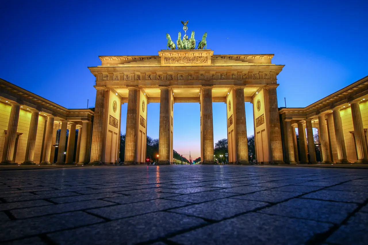 The Brandenburg Gate illuminated at night with a clear blue sky in Berlin