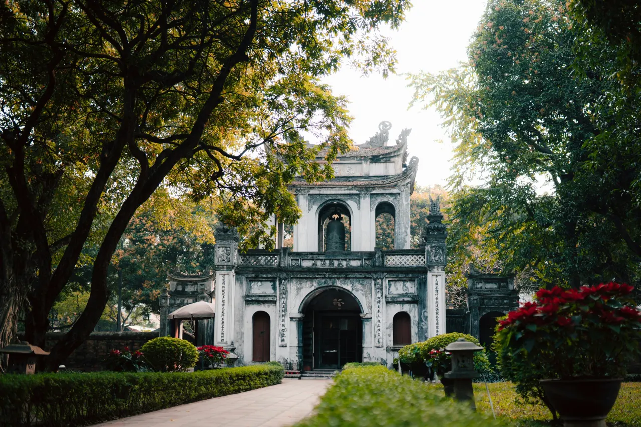 a large white building surrounded by trees and bushes