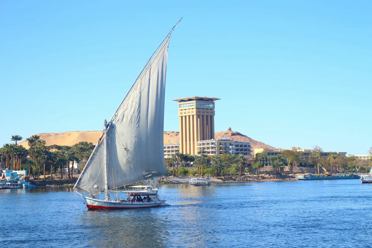 white sail boat on water near city buildings during daytime